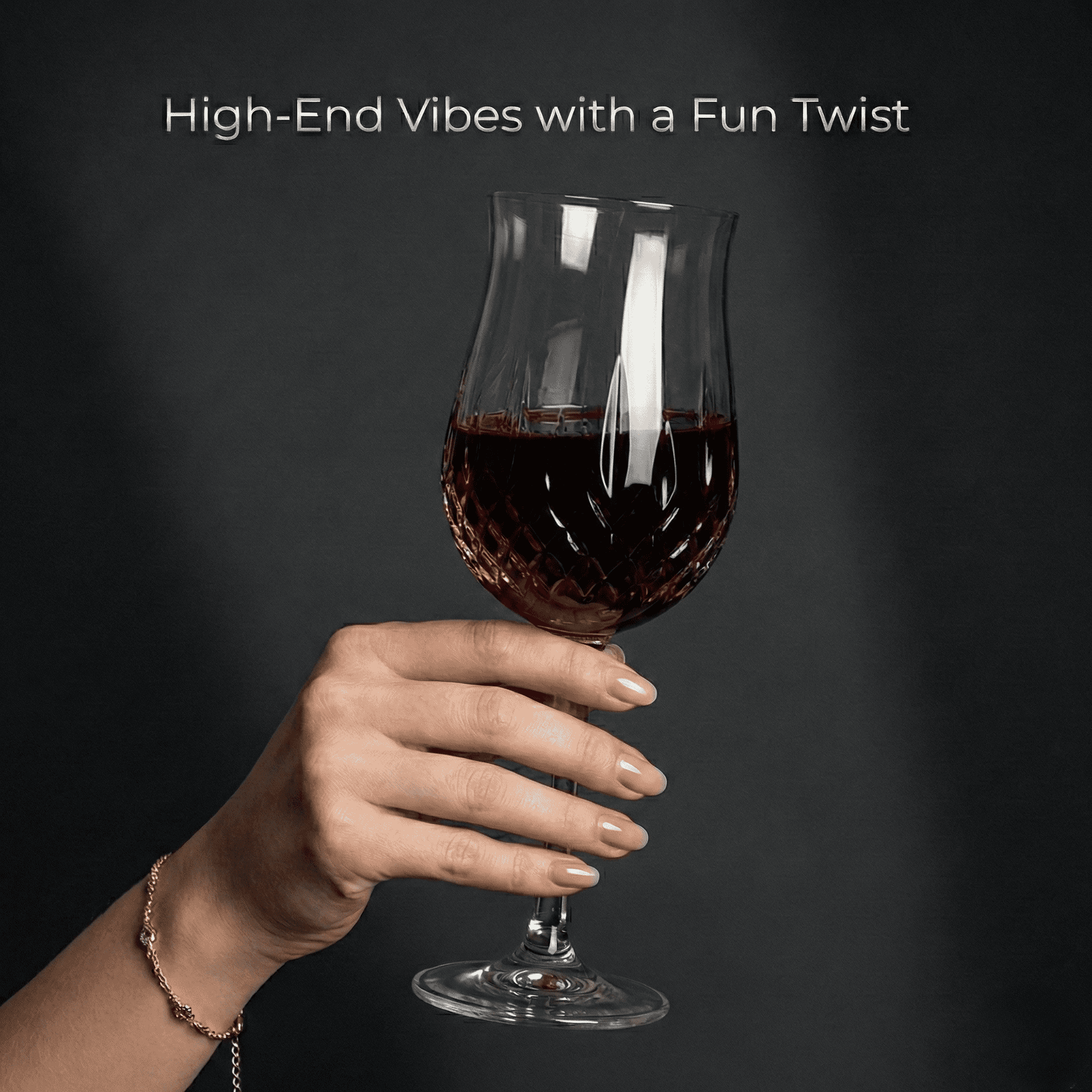 A hand with stylish nails holding a cut-glass wine glass.